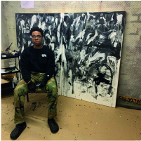 Portrait of Khari Worrell sat in front of large abstract painting.